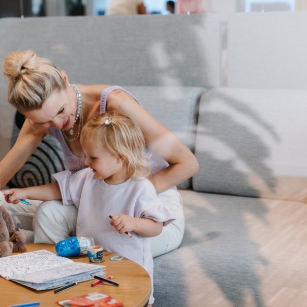 Woman playing with her toddler in the office.